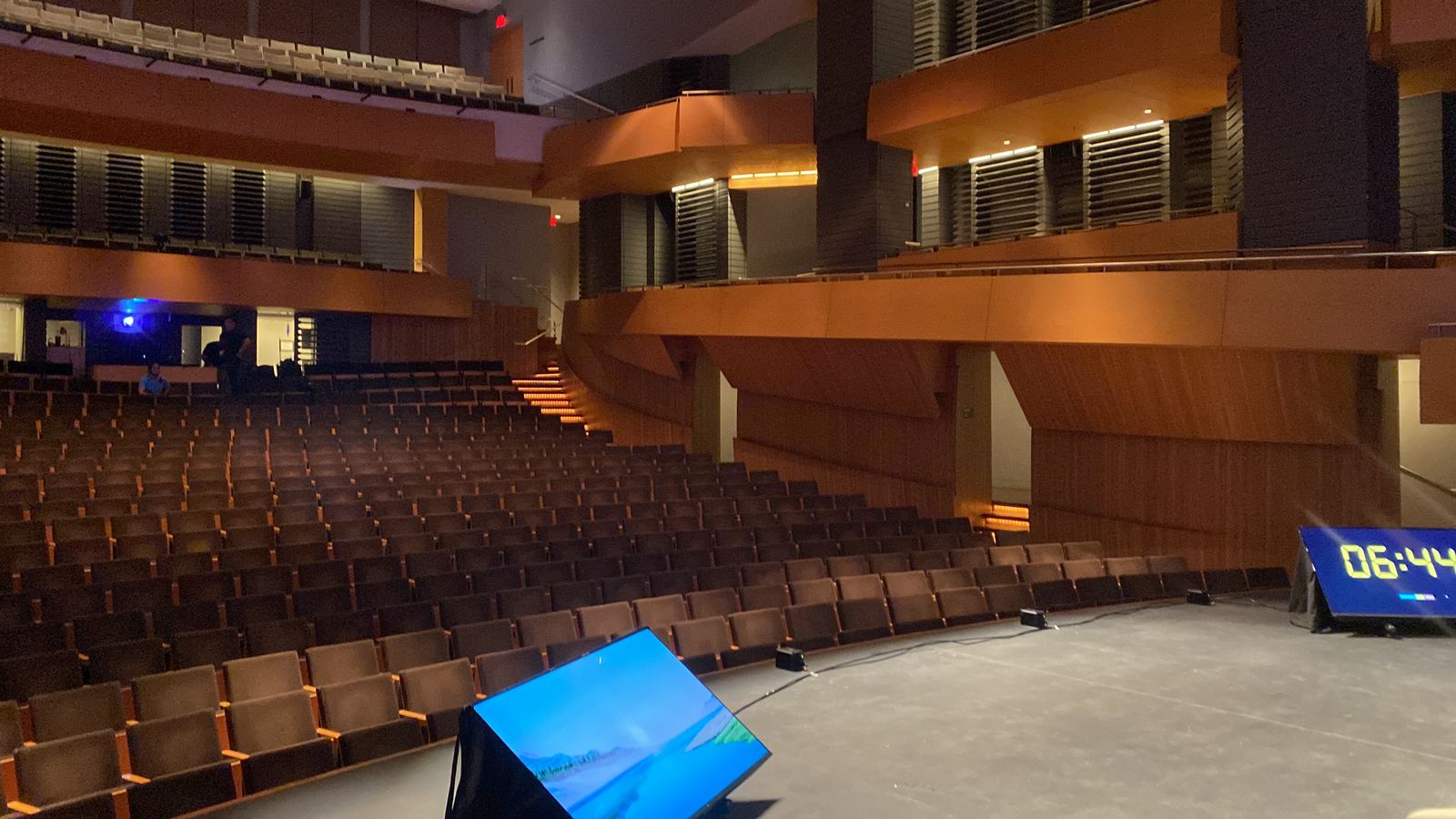 Auditorio ordenado con escenario, pantalla de retorno y equipos listos antes de un evento