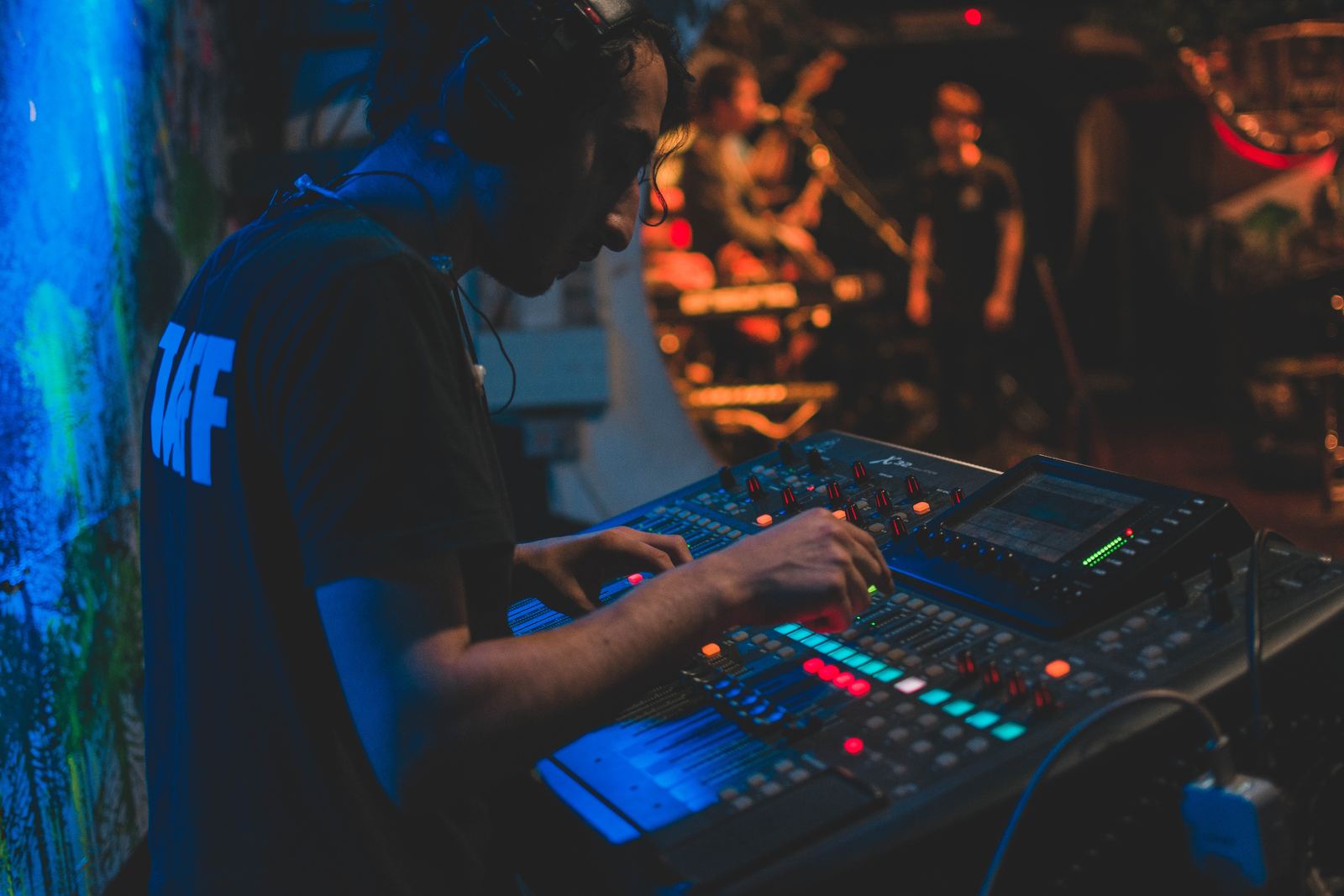 Consola de audio digital operada por un técnico de T60, con pantalla LED azul de fondo
