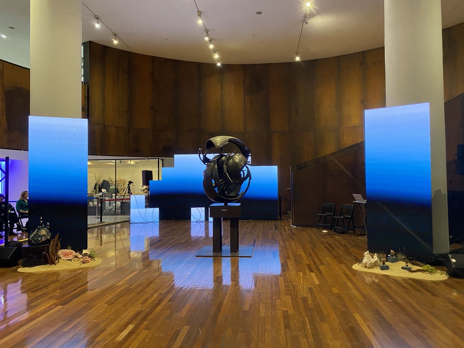 Montaje corporativo en un hall con columnas de pantalla LED y escenografía central